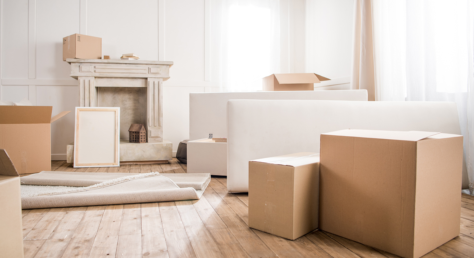 Picture frame and cardboard boxes in empty room, relocation conc