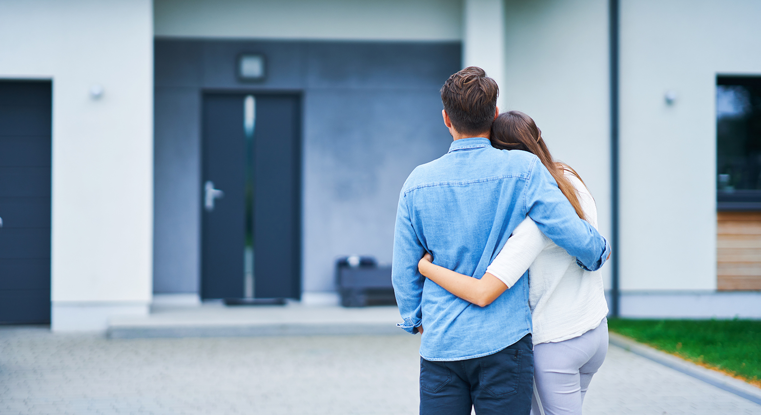 Home-Mortgages Couple in front of one-family house in modern residential area